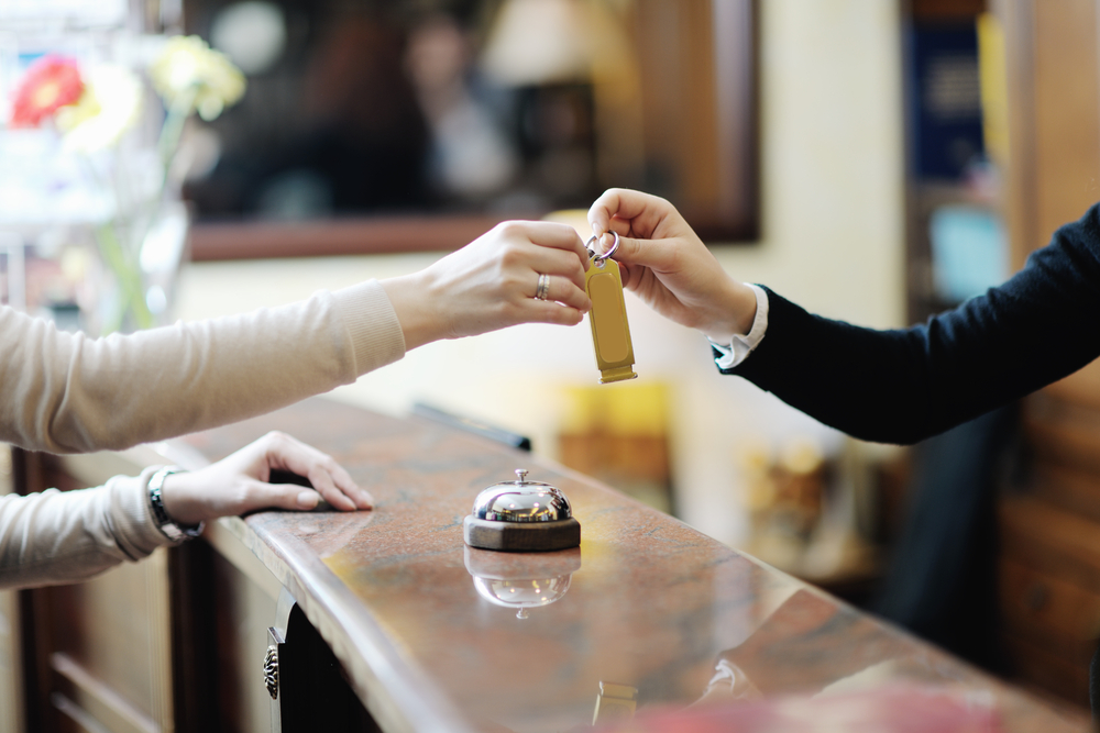 Woman checking in at hotel reception desk